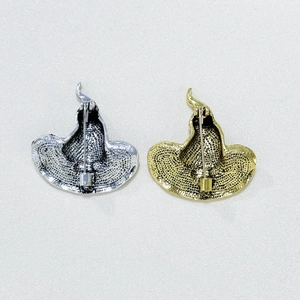 Detail of metal pin back mechanism and textured surface on witch hat brooches