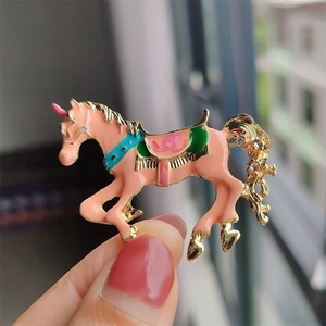 Spilla a forma di cavallo zodiacale in smalto rosa, dettagli dorati e strass brillanti