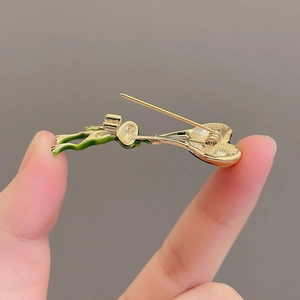 Gros plan sur l'épingle en métal et le fermoir doré au dos du badge grenouille mignonne