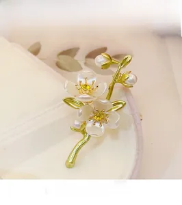 Macro detail of jasmine flower brooch with white petals, yellow crystal and pearl accents