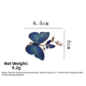 Détail de la broche papillon en broderie bleue avec perle, dimensions 6,5cm par 5cm