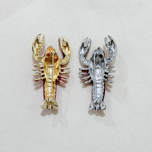 Exquisite lobster brooches in gold and silver showing detailed back clasp on silk
