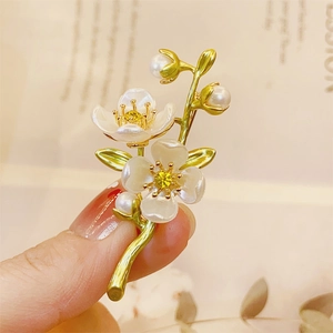 Detailed macro of a handmade jasmine flower brooch with white petals and pearls