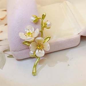 Detailed view of jasmine flower brooch with white petals, green stem and pearls