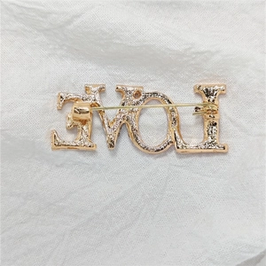 Goldene LOVE Buchstaben Brosche mit gehammerter Metallstruktur und Nadelverschluss