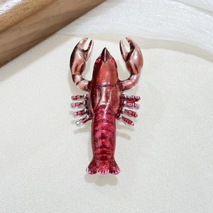 Vintage red lobster brooch with gold glitter and crystals on white textured fabric