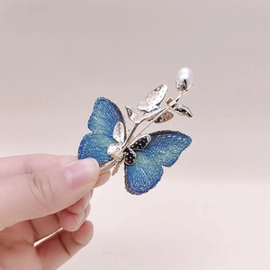 Broche papillon vintage élégante avec ailes bleu dégradé, touches dorées et perle blanche