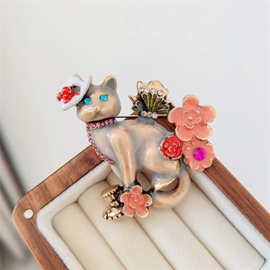 Broche chat vintage avec fleurs en émail et strass brillants dans un écrin de bijoux