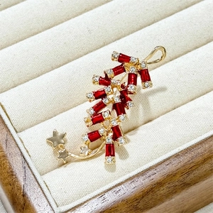 Broche de pétard exquise avec émail rouge et strass sur un coffret en velours beige
