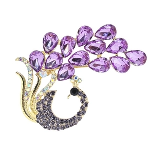Elegant gold peacock brooch with vibrant purple teardrop gems and sparkling crystals