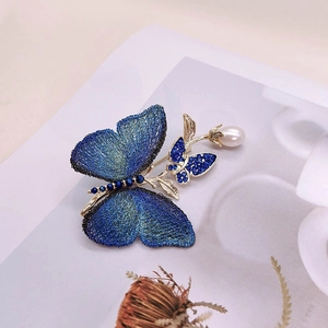 Broche papillon vintage en maille bleue avec cristaux étincelants et perle blanche raffinée