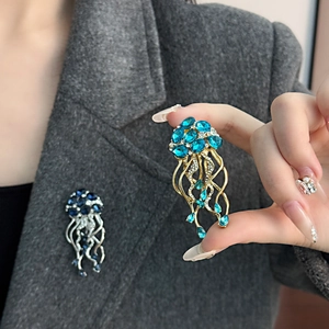 Vue détaillée de luxueuses broches méduse en cristal épinglées sur une veste en laine