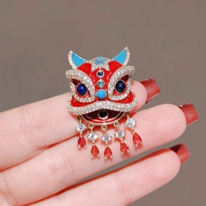Traditional Chinese dancing lion brooch with red enamel and hanging ruby-like tassels