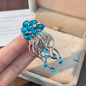 Élégante broche méduse aux cristaux bleu ciel et tentacules argentés sur écrin
