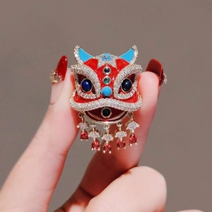 Chinese style lion dance brooch with red enamel and hanging ruby-red crystal tassels