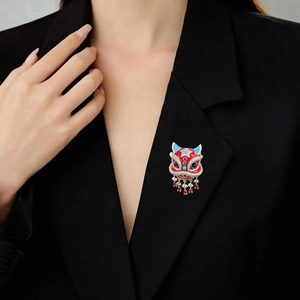 Detailansicht einer Emaille-Löwenbrosche mit Quasten auf einem schwarzen Blazer