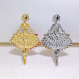 Macro view of the back of ballet dancer brooches showing metal texture and pin clasp