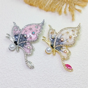 Elegant butterfly brooches with enamel and crystals on a light textured background