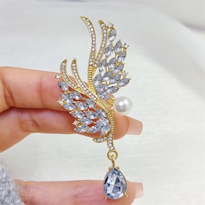 Élégante broche ailes d'ange avec cristaux micro-pavés et pendentif perle bleue