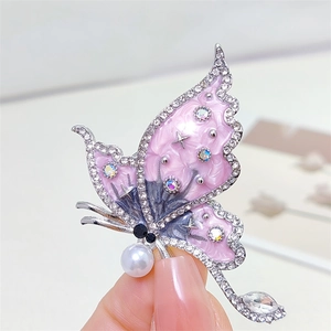 Elegant butterfly brooch with pink enamel wings and pearl detail for luxury styling