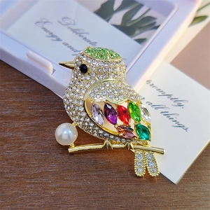Exquisite magpie bird brooch with colorful crystals and pearl on a golden branch base