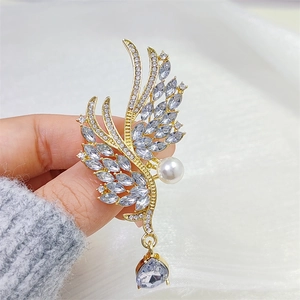 Broche ailes d'ange dorée avec cristaux scintillants et pendentif en goutte