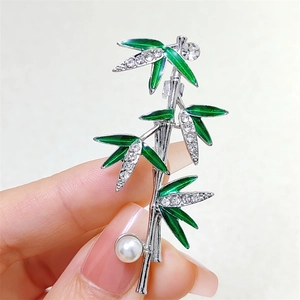 Bamboo brooch with green enamel leaves, clear rhinestones, and white pearl decoration