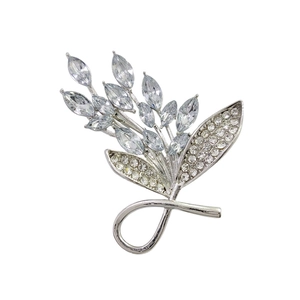 Elegant emerald green leaf brooch with sparkling crystals on a silver metal base