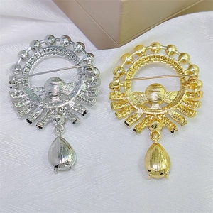 Detail view of the back of gold and silver sunburst brooches with pin fasteners