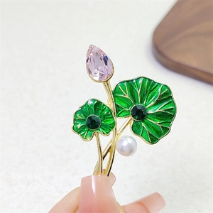 Squisita spilla foglia di loto con cristalli rosa, smalto verde e perla in mano
