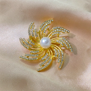 Broche étoile dorée élégante avec perle centrale et strass étincelants sur satin