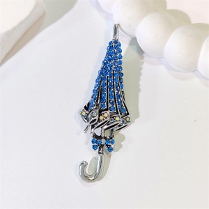 Elegante spilla a ombrello argentata con strass blu scintillanti e un fiocco a farfalla
