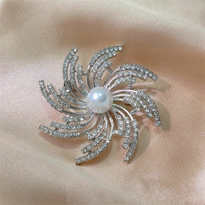 Élégante broche rayon de soleil argentée avec zircons brillants et une perle blanche