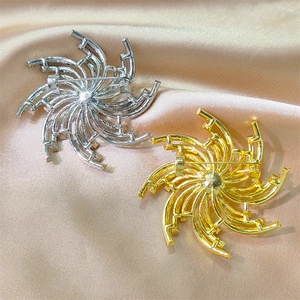 Gros plan de broches soleil en or et argent avec zircons sur un tissu en soie satiné