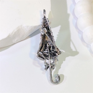 Dettaglio della spilla a ombrello argento con chiusura a rotazione sicura sul retro