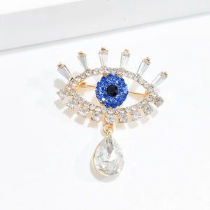 Luxury evil eye brooch with blue crystals and pear-shaped pendant on gold metal