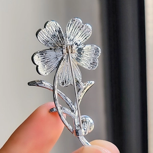 Detailansicht des Sicherheitsverschlusses der silbernen Blumenbrosche mit feiner Textur