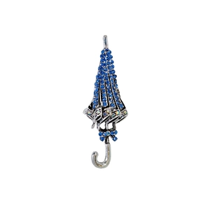 Elegante spilla a ombrello in argento con strass blu e manico a J su sfondo bianco