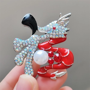 Détail de la broche caractère Fu en forme de dragon avec émail rouge et strass brillants