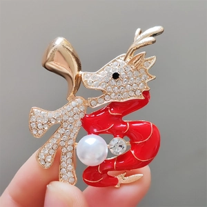 Détail macro d'une broche dragon chinois en émail rouge avec perle blanche fine