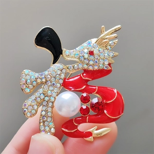 Détail d'une broche dragon chinois en émail rouge avec perles et finitions dorées