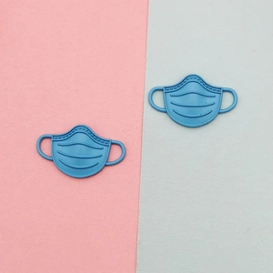 Macro detail of blue matte mask-shaped alloy charms for DIY jewelry and accessories