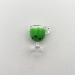 Macro detail of a miniature green bubble tea cup model with black pearls and tiny handle