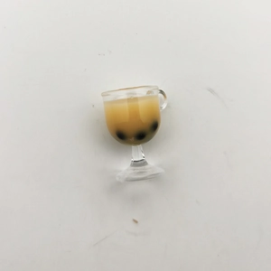 Macro view of miniature bubble tea glass model with brown liquid and black pearls