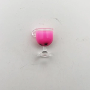 Macro detail of miniature bubble tea glass with pink liquid and tiny black pearls