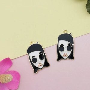 Detalle de colgantes de chica de dibujos animados con boina negra y gafas de sol en metal