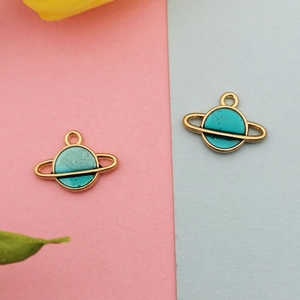Detailed close-up of gold-plated Saturn charms with blue enamel for DIY jewelry making