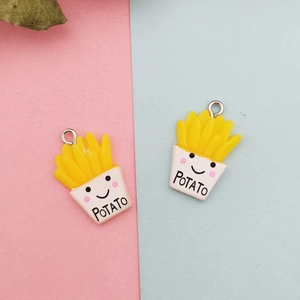 Détail de pendentifs frites en résine jaune avec anneaux pour création de bijoux