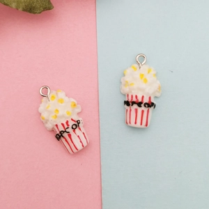 Détail de breloques popcorn en résine avec boîtes rayées rouges et boucles argentées