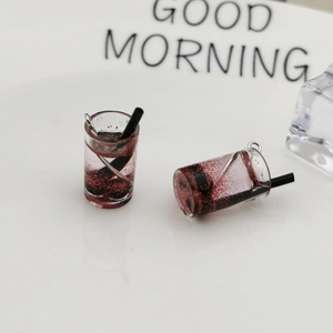 Makroansicht von Mini Bubble Tea Harzanhängern mit schwarzen Strohhalmen für DIY-Schmuck